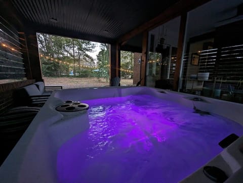 Unwind in this romantic spa-style hot tub with mood lighting, privacy, and views of the lush garden—perfect for couples' relaxation.