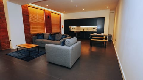 Spacious lounge with grey sofas, wood coffee table, and accent lights – The Nichols Bldg, Sheffield
