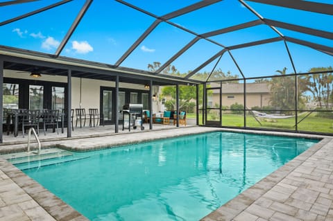 A beautiful pool is nestled within a screened-in patio, offering a serene oasis shielded from insects and the elements. This enchanting setup allows residents and guests to enjoy a refreshing swim or simply lounge by the poolside, surrounded by the beauty of the outdoors without any disturbances. It provides a tranquil and private space to unwind, soak up the sun, and relish mo...