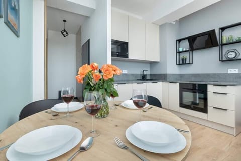 A dining area with a round wooden table set for a meal, decorated with a vase of fresh flowers for a welcoming touch.