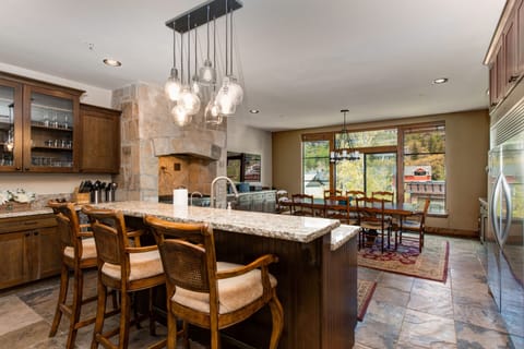 - Gather around the stone accented kitchen with wooden cabinetry and cozy bar stools
- Enjoy meals in the spacious dining area with panoramic window views of the hillside
- Statement pendant lighting adds a warm glow to your evenings
