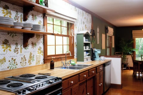 Vintage stove and wallpaper bring a nostalgic vibe to this fully stocked kitchen