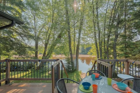 Deck dining area with table set for outdoor meals and lake views