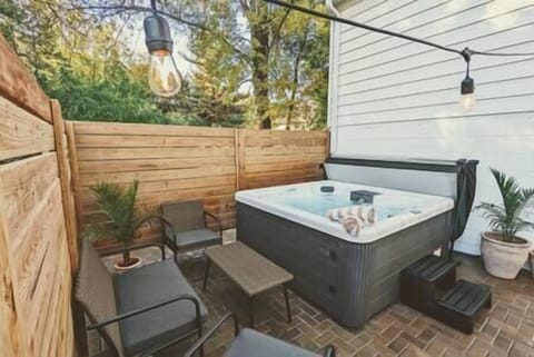 Outdoor seating area with patio lights and hot tub.