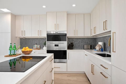 The island’s quartz counter sparkles like mermaid treasure, holding oranges and sparkling water like honored guests   