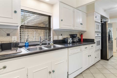 Those striking white cabinets are filled with cookware, dining ware, utensils, and glasses for you to use, too!