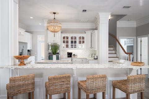 Gather around your bright, open kitchen featuring granite countertops, white cabinetry, and a welcoming breakfast bar perfect for morning coffee.
