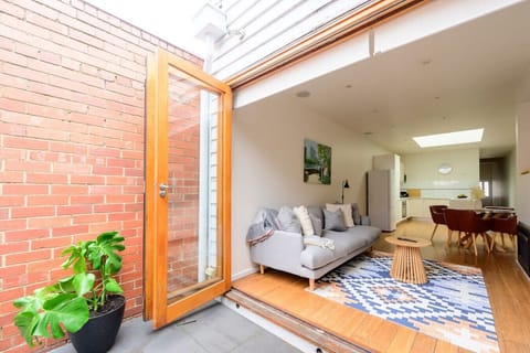 Open-plan living room is equipped with wide glass doors that can be opened, allowing for a refreshing airflow and a connection with the outdoors.