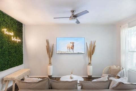 Don’t let the cow fool you! It’s a 65 inch Roku TV equipped with HBO, NETFLIX, & HULU. The vases with pompis grass, coffee table and a real Champaign cowhide bring this living room all together.