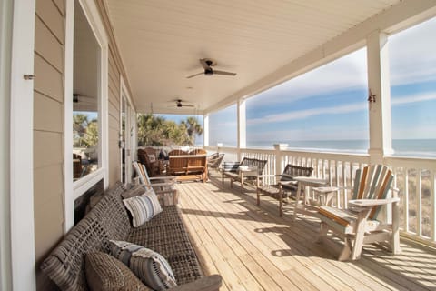 Relax on your expansive oceanfront deck with wicker seating and Adirondack chairs, where ceiling fans keep you cool as you soak in stunning sea views.