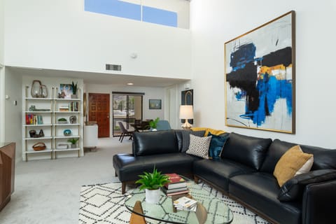 Bright and open living room looking toward the dining area and front entry.