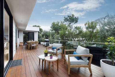 A bright and breezy back deck features a brand-new al fresco dining setting for eight, as well lounge seating