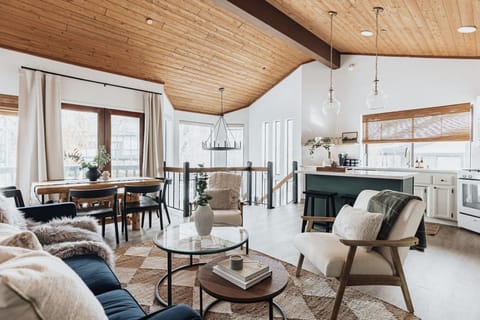 Open concept light filled living, dining + kitchen w/ beautiful vaulted ceilings