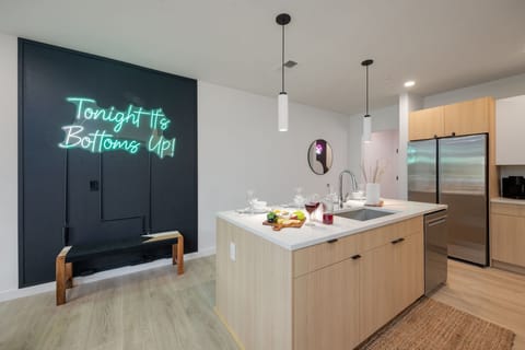 Fully equipped modern kitchen with basic cooking essentials, stainless steel appliances, island bar seating, Keurig coffee machine, and wet bar.