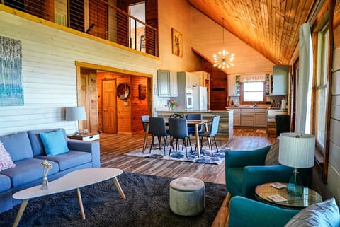 Great room and kitchen with view of upstairs bedroom and bathroom entrances.