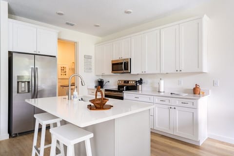 WELL-EQUIPPED KITCHEN: This area is where culinary adventures come to life.  The kitchen island takes center stage, providing ample workspace and a hub for casual dining.