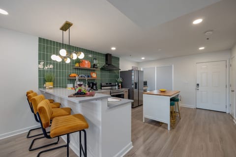 (1st Floor) Fully equipped kitchen with stainless steel appliances, basic cooking essentials, and kitchen island seating.