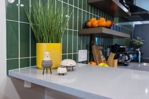 (1st Floor) Fully equipped kitchen with stainless steel appliances, basic cooking essentials, and kitchen island seating.