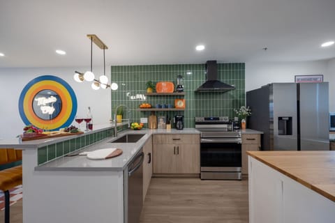 (1st Floor) Fully equipped kitchen with stainless steel appliances, basic cooking essentials, and kitchen island seating.