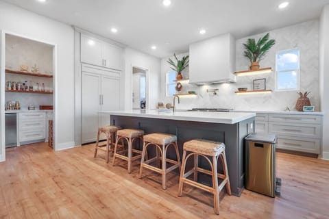 The heart of the kitchen — a bright, roomy island with bar stools and lots of space to connect while cooking... and a cocktail bar area just off the kitchen with an ice maker, glassware, and all the bar tools you’ll need