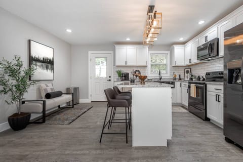 View of the fully equipped kitchen with granite counters, stainless steel appliances and island with seating for 2