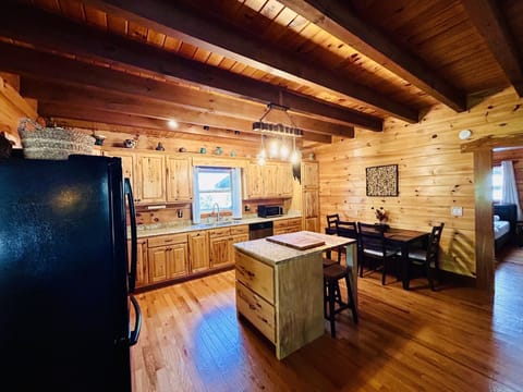 Open concept kitchen with custom butcher block island and 3 bar stools. 