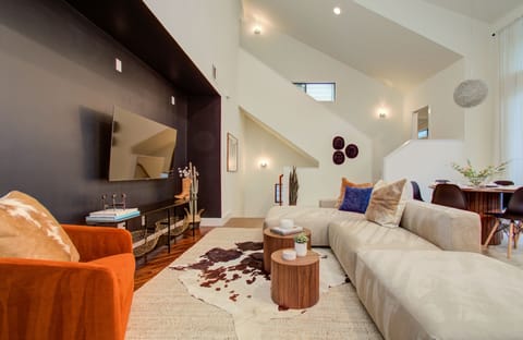 Living room with large TV and cozy couch sets with modern minimalist interior