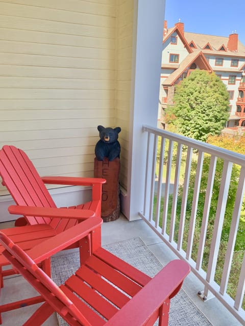 Covered balcony with Adirondack chairs and table