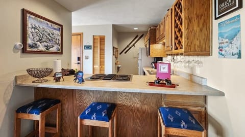 The view into the kitchen from over the kitchen bar where you will find 3 bar stools providing additional seating.