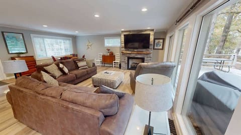 Inviting living area featuring ample seating, a warm fireplace, and wall TV.