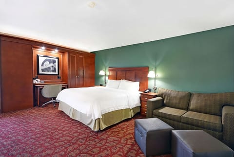 Unwind in a spacious king room with cozy lounge seating.