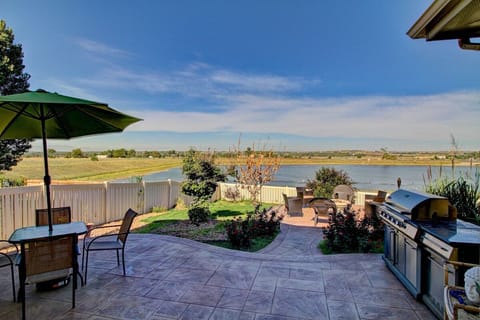 Enjoy lakeside dining and outdoor grilling in this serene paved patio oasis, complete with a shaded dining area and a BBQ grill, all against the stunning backdrop of the lake.