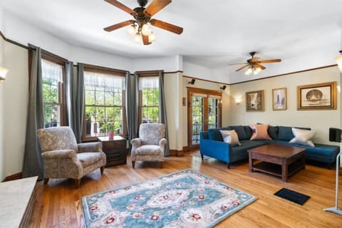  Spacious living room features a cozy couch, ceiling fans and natural light.