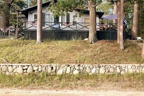 Front of house from parking spots located across dirt road at bottom of hill