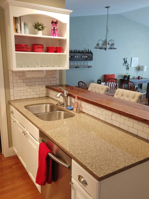 Kitchen sink and dishwasher allow for easy clean-up. Countertop bar seats 3