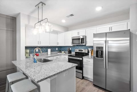 Open Kitchen and Dining Area with Stainless Steel Appliances and Kitchen Essentials