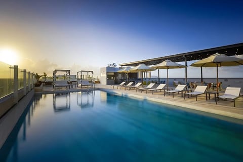 Glide into the sparkling rooftop pool with ocean breezes.