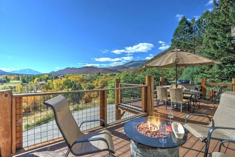 Deck with fire pit and dining area with views