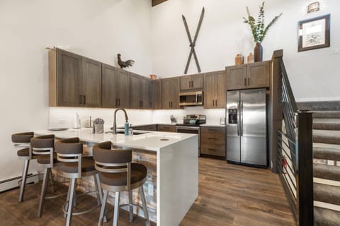 Modern kitchen with sleek countertops, bar stools, and plenty of space—perfect for casual dining or entertaining!