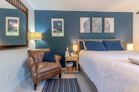This room features a queen bed with a heated blanket and a smart TV. 