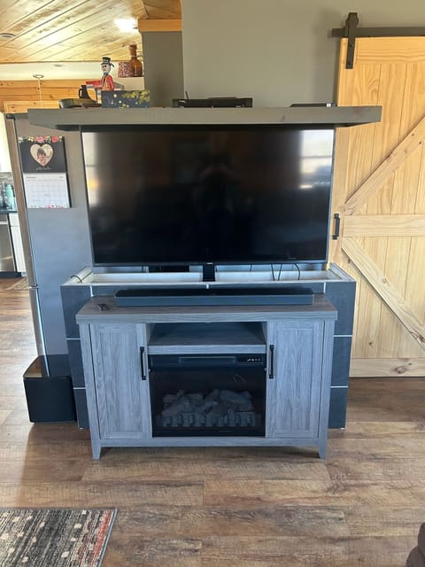 TV with hide-away cabinet with electric fireplace.