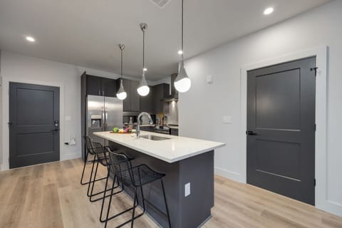 Fully equipped kitchen stocked with your basic cooking essentials. Includes stainless steel appliances, kitchen island, coffee machine, and toaster.