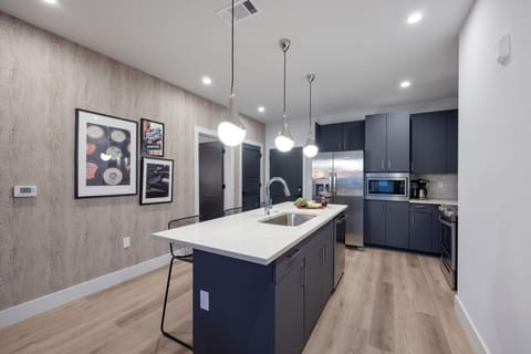 Fully equipped kitchen stocked with your basic cooking essentials. Includes stainless steel appliances, kitchen island, coffee machine, and toaster.