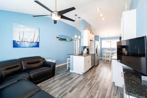 Open-concept living area with coastal blue walls and modern kitchen amenities.