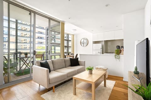 A light and airy open-plan living space includes a large sofa and TV to settle in with a movie after a day of work or sightseeing. 
