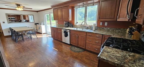 This fully equipped kitchen features stainless steel appliances & ample cabinet space. Ideal for preparing meals it boasts a gas stove, dishwasher, coffee maker, & a large dining table for the family. Enjoy the meadow views through the large windows!