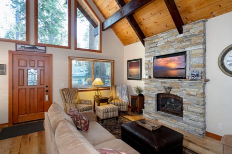Enjoy a cozy retreat in this living room with a large TV for streaming, a gas fireplace to set the mood, ample seating, and two armchairs ideal for reading and relaxing