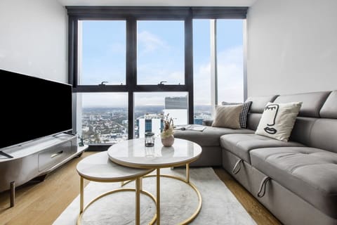 The open plan living room is framed by full height windows, capturing spectacular vistas across the city skyline.