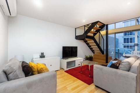 A grand staircase up to the lofted bedrooms defines the living area.