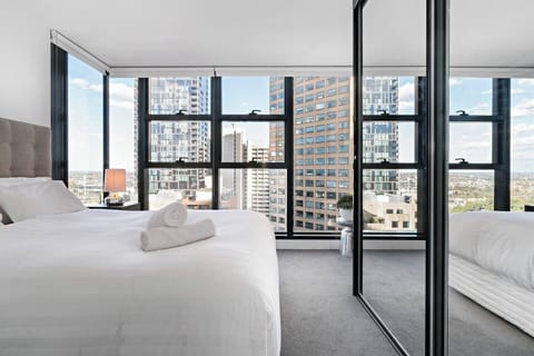The master bedroom is drenched in natural light, with floor-to-ceiling windows.